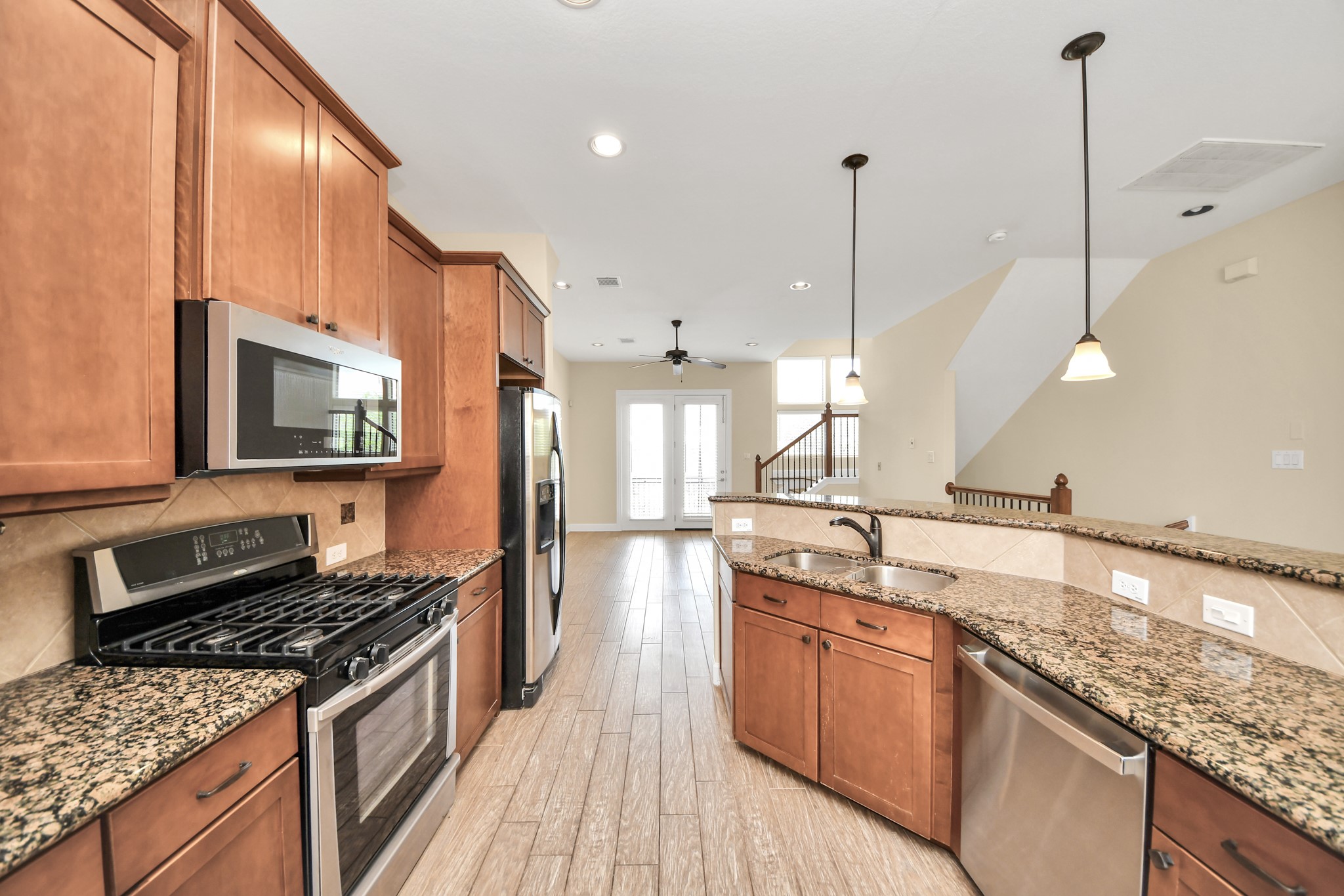 2830 Polk Street Houston, TX 77003 - Photo 11 of 21 The kitchen combines timeless finishes with functional design, featuring granite countertops, stainless steel appliances, a stylish tile backsplash, pendant lighting, and an impressive amount of cabinetry for storage.