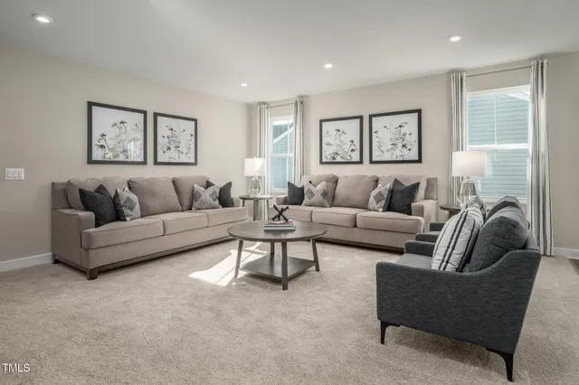 a living room with furniture and a dining table with kitchen view