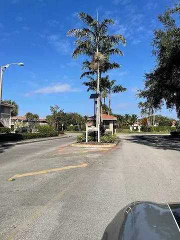 a front view of a house with palm trees