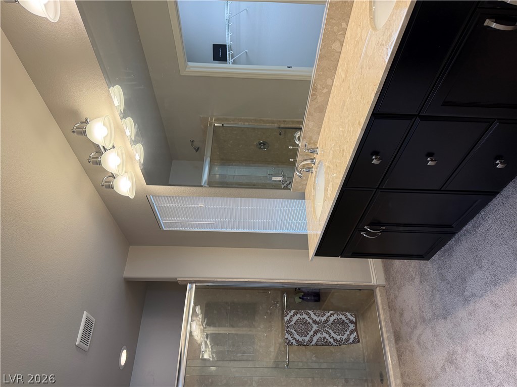 6385 Jackson Spring Road Las Vegas, NV 89118 - Photo 24 of 36 Double vanity with stone counters and a spacious glass-enclosed shower complement this well-appointed bathroom.
