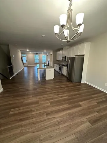 a view of a dining room with furniture a chandelier and wooden floor