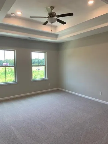 an empty room with a window and a ceiling fan