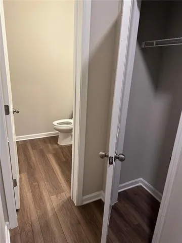 a view of a bathroom with wooden floor and toilet