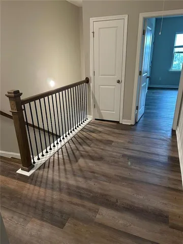 a view of a hallway with wooden floor and stairs