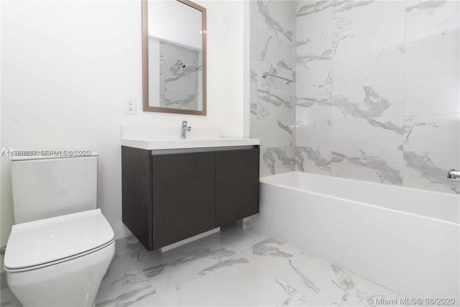 851 Northeast 1st Avenue, Unit 3601 Miami, FL 33132 - Photo 16 of 49 a bathroom with a sink a toilet and bathtub