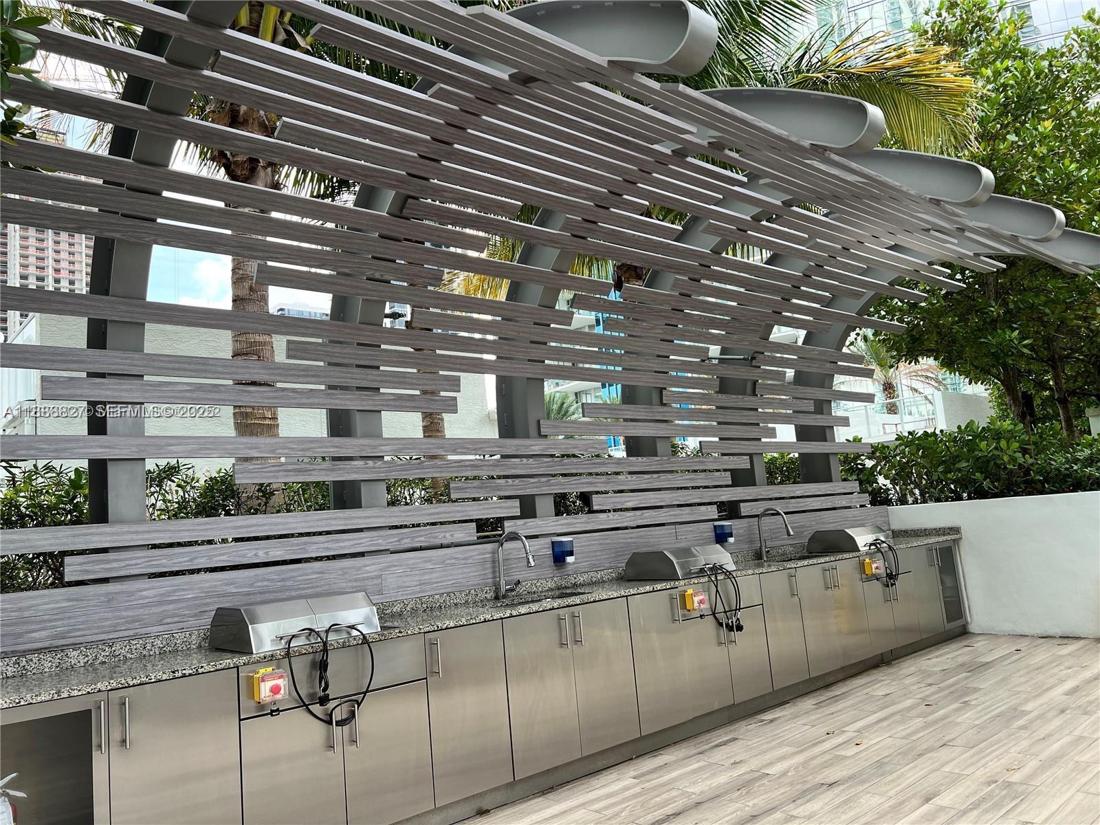 851 Northeast 1st Avenue, Unit 3601 Miami, FL 33132 - Photo 30 of 49 a open kitchen with stainless steel appliances wooden cabinets and stove top oven