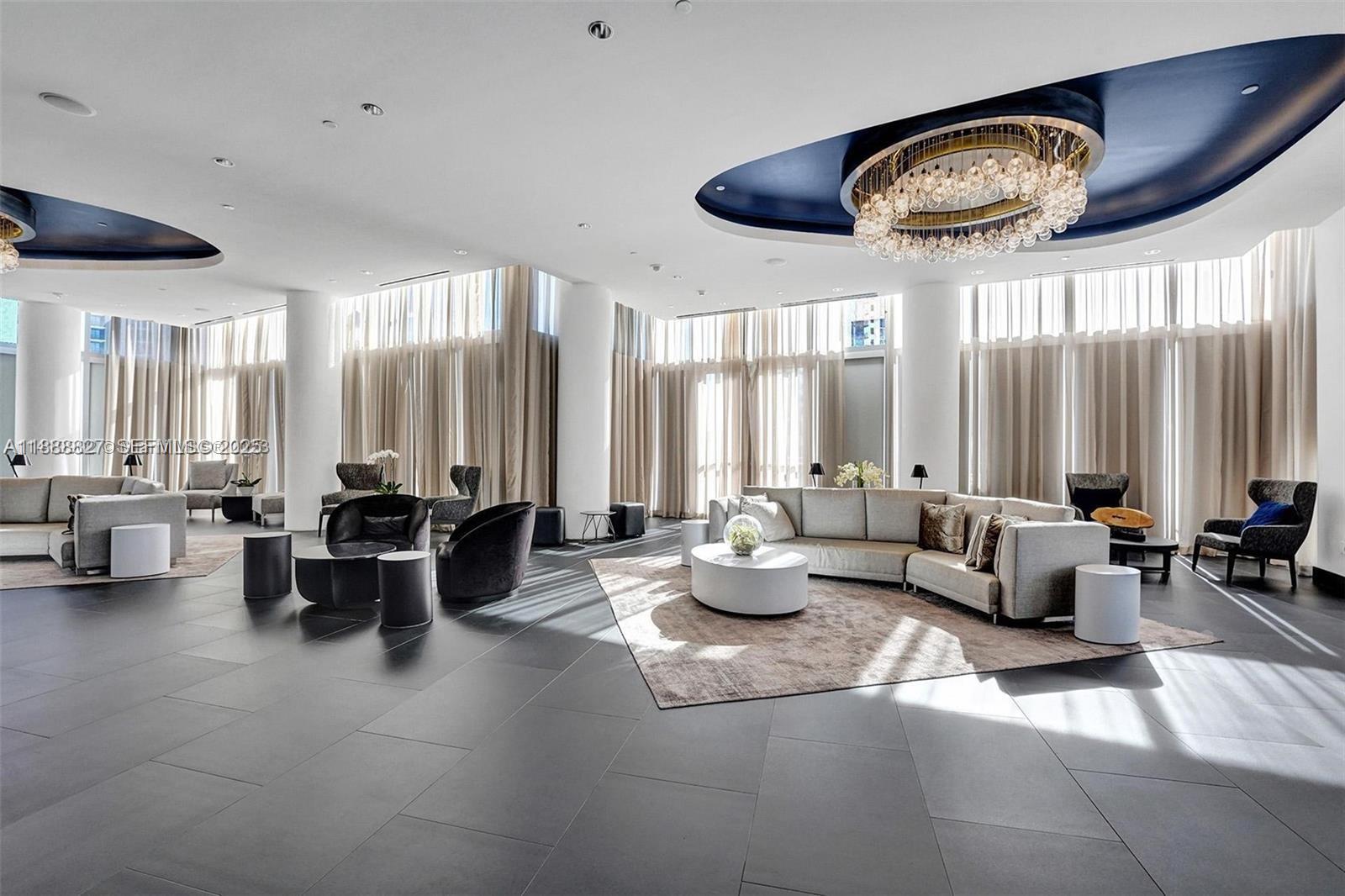 851 Northeast 1st Avenue, Unit 3601 Miami, FL 33132 - Photo 42 of 49 a living room with furniture a large window and a chandelier