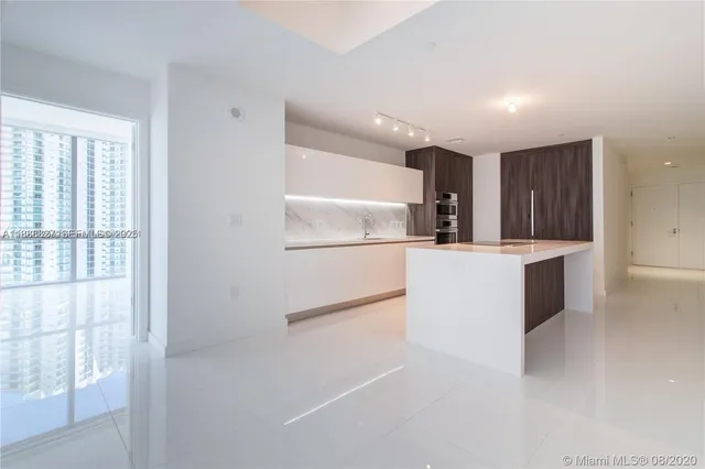 a kitchen with granite countertop a refrigerator and a sink