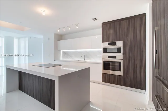 a kitchen with kitchen island stainless steel appliances a sink and counter space