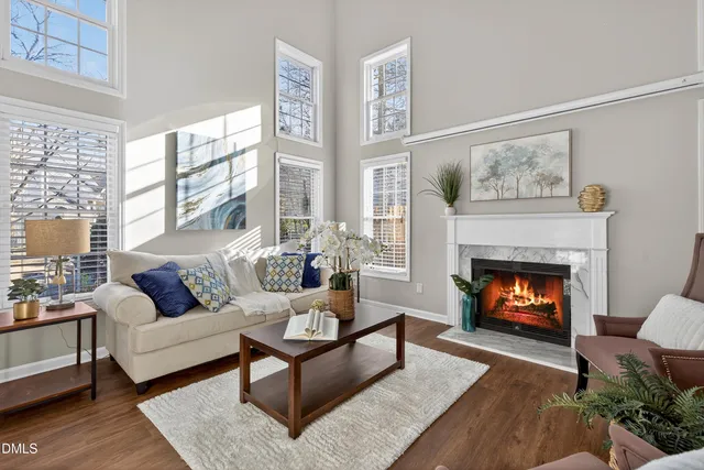 a living room with furniture potted plant and kitchen view