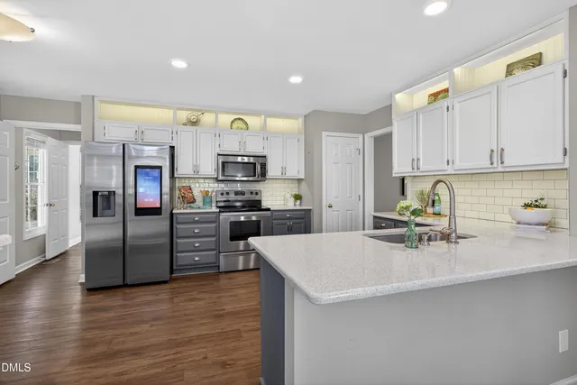 a kitchen with stainless steel appliances a stove a refrigerator and a sink