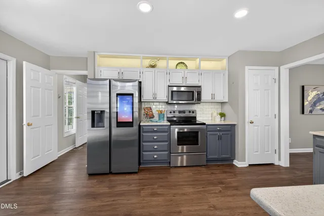 a kitchen with stainless steel appliances a refrigerator and a stove top oven