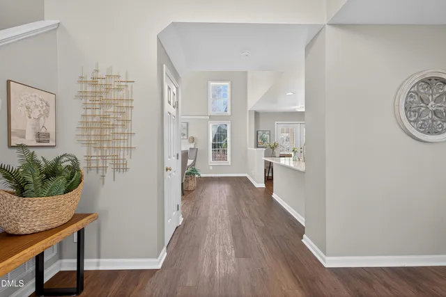 a view of a hallway with wooden floor and a living room