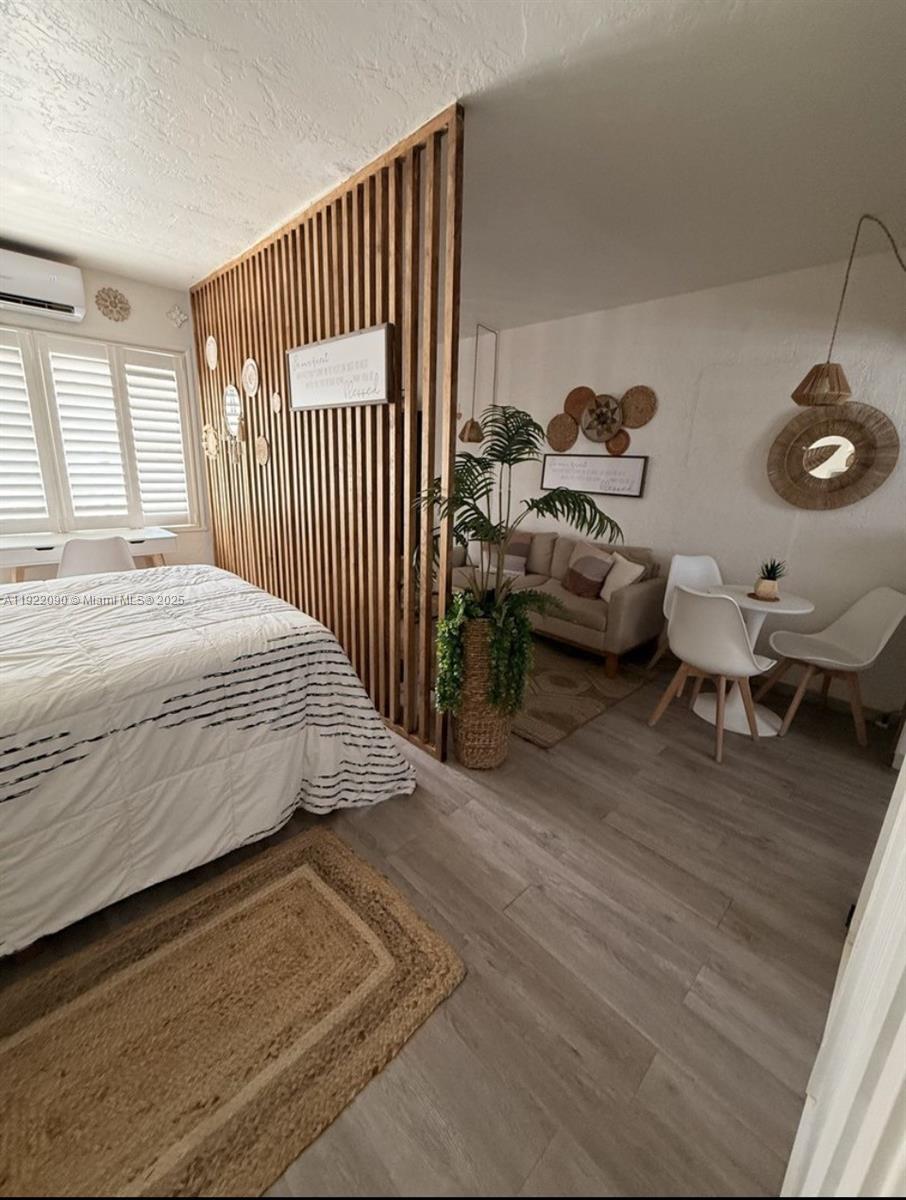 309 Crocus Terrace, Unit 9 Hollywood, FL 33019 - Photo 5 of 10 a bedroom with a bed and wooden floor