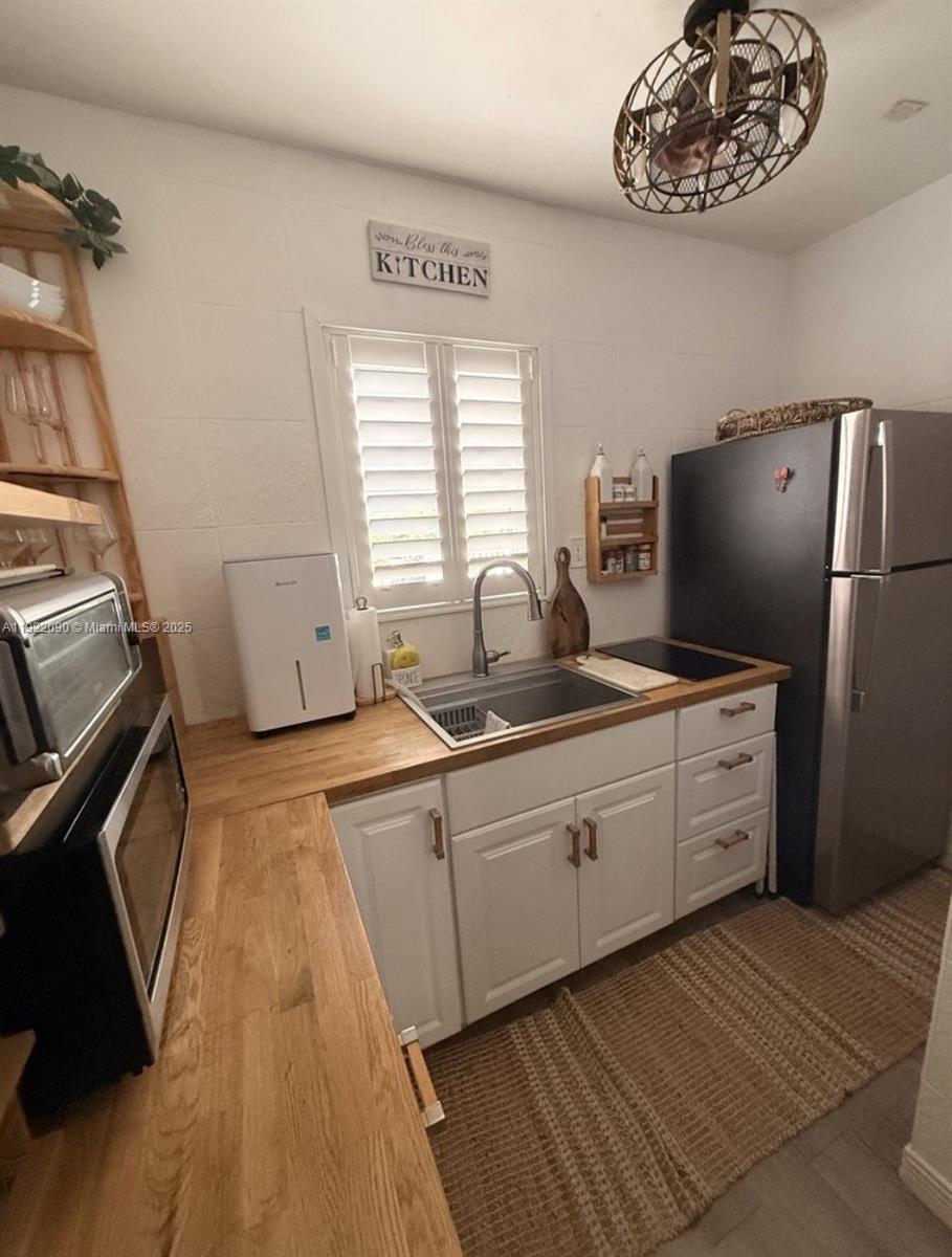 309 Crocus Terrace, Unit 9 Hollywood, FL 33019 - Photo 6 of 10 a kitchen with white cabinets and stainless steel appliances
