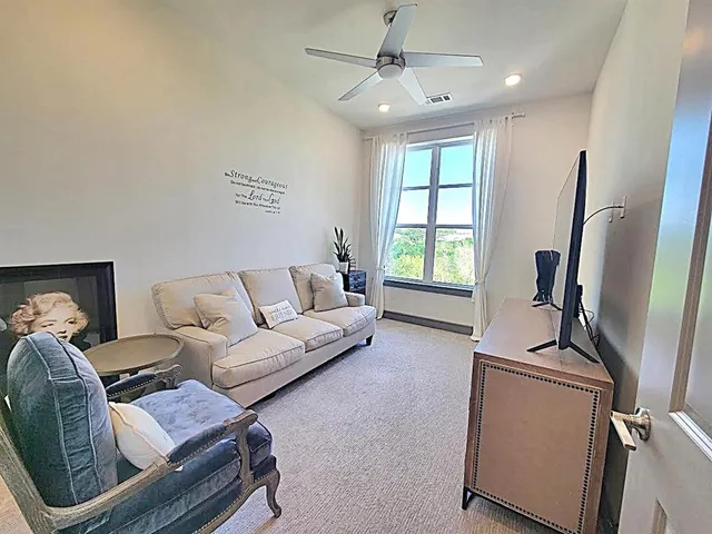 a living room with furniture a window and a flat screen tv