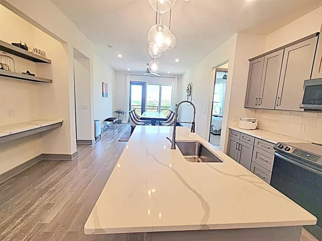 a kitchen with sink a refrigerator and chairs