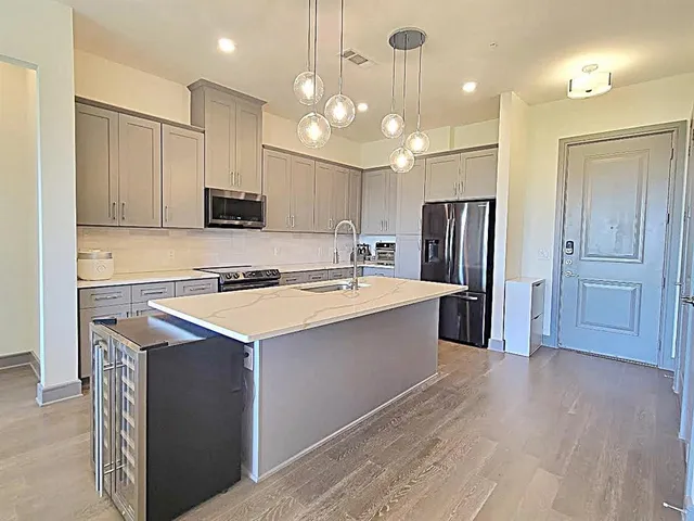 a kitchen with kitchen island a sink stainless steel appliances and refrigerator