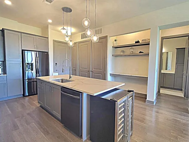 a kitchen with kitchen island a counter top space a sink stainless steel appliances and cabinets