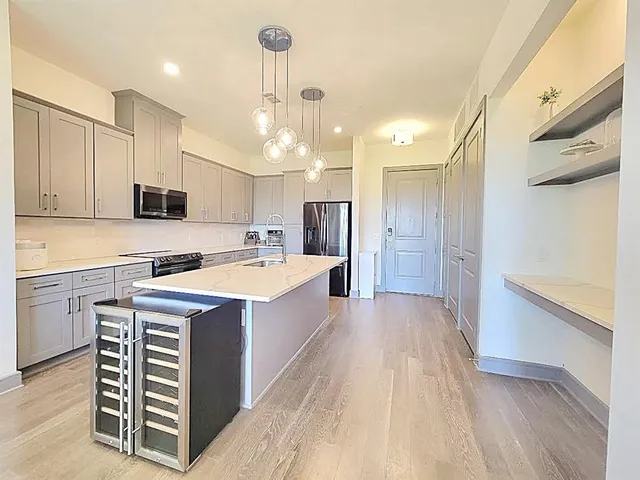 a kitchen with a sink a counter top space stainless steel appliances and cabinets