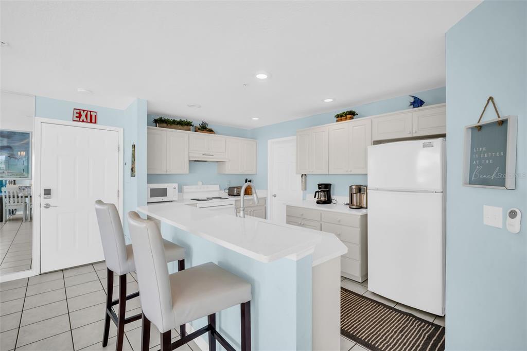1802 Gulf Boulevard, Unit 12 Indian Rocks Beach, FL 33785 - Photo 12 of 41 a kitchen with white cabinets and white stainless steel appliances