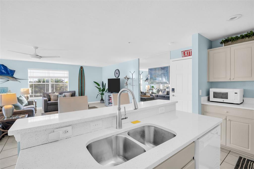 1802 Gulf Boulevard, Unit 12 Indian Rocks Beach, FL 33785 - Photo 13 of 41 a kitchen with sink a refrigerator and chandelier