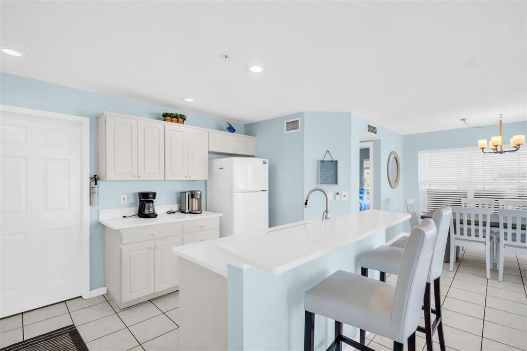 1802 Gulf Boulevard, Unit 12 Indian Rocks Beach, FL 33785 - Photo 16 of 41 a kitchen with white cabinets and stainless steel appliances