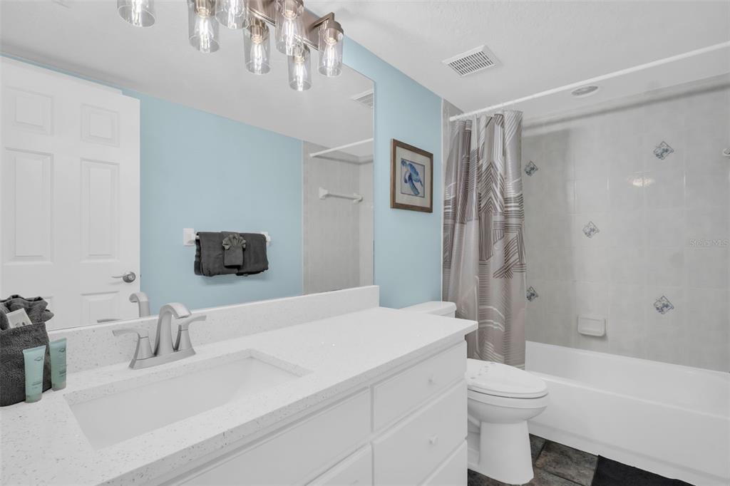 1802 Gulf Boulevard, Unit 12 Indian Rocks Beach, FL 33785 - Photo 21 of 41 a bathroom with a sink a toilet and shower