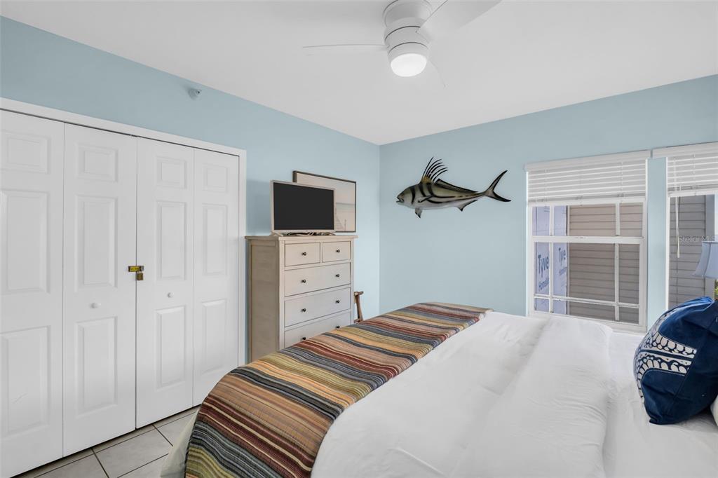 1802 Gulf Boulevard, Unit 12 Indian Rocks Beach, FL 33785 - Photo 25 of 41 a bedroom with a bed and a flat tv screen on the dresser