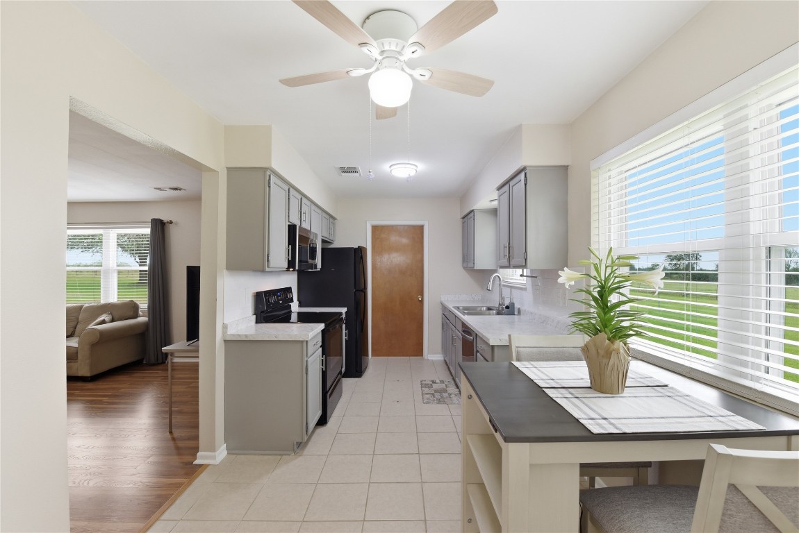 1250 Stockwell Damon, TX 77430 - Photo 20 of 50 a kitchen with stainless steel appliances kitchen island granite countertop a refrigerator a sink dishwasher a stove and a dining table with wooden floor