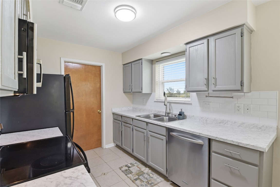 1250 Stockwell Damon, TX 77430 - Photo 21 of 50 a kitchen with stainless steel appliances granite countertop a sink refrigerator and cabinets