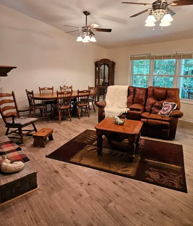 a living room with furniture a chandelier and a rug
