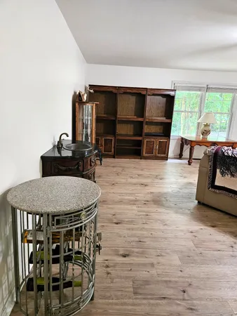 a living room with furniture a flat screen tv and a large window