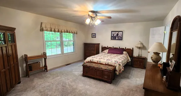 a bedroom with a bed dresser and a window