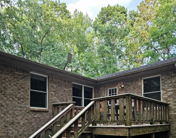 a view of wooden house with a small yard
