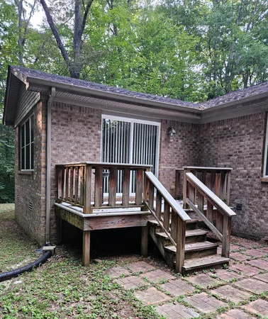 a balcony with wooden floor stairs and a roof