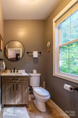 a bathroom with a toilet a sink and mirror