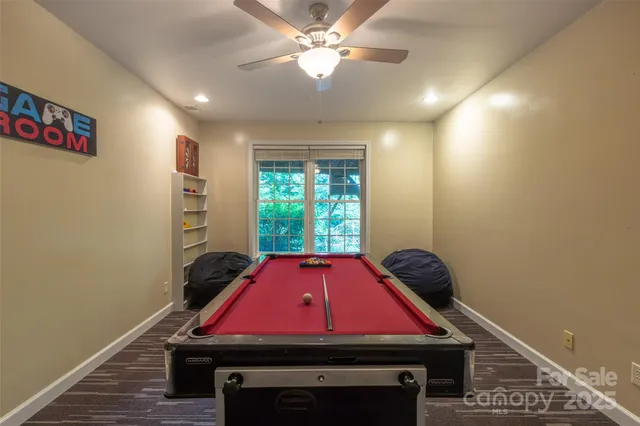 a room with pool table and windows