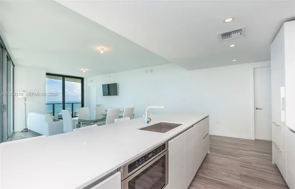a kitchen with a sink and wooden floor