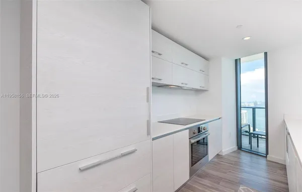 a kitchen with cabinets and wooden floor