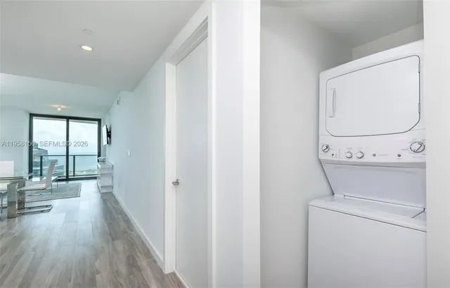 a view of washer and dryer with bathroom in the background