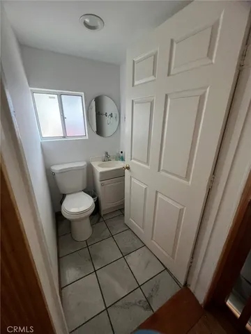 a bathroom with a sink a toilet a mirror a vanity and window