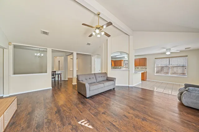 a living room with furniture and a wooden floor