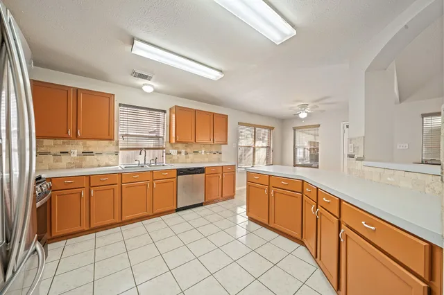 a large kitchen with granite countertop cabinets stainless steel appliances a sink and a window