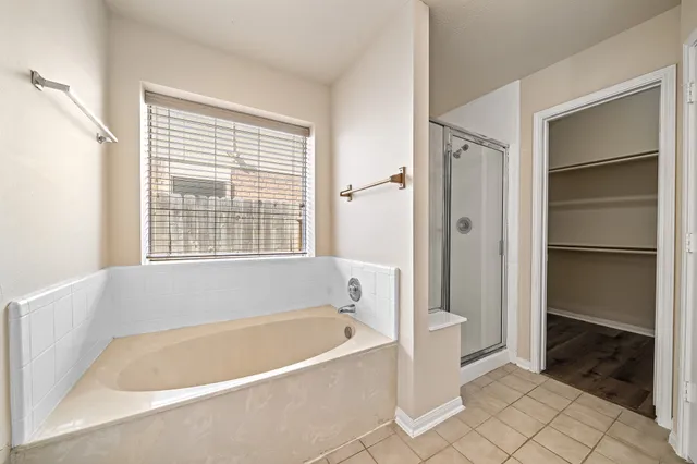 a white bath tub sitting in a bathroom next to a window