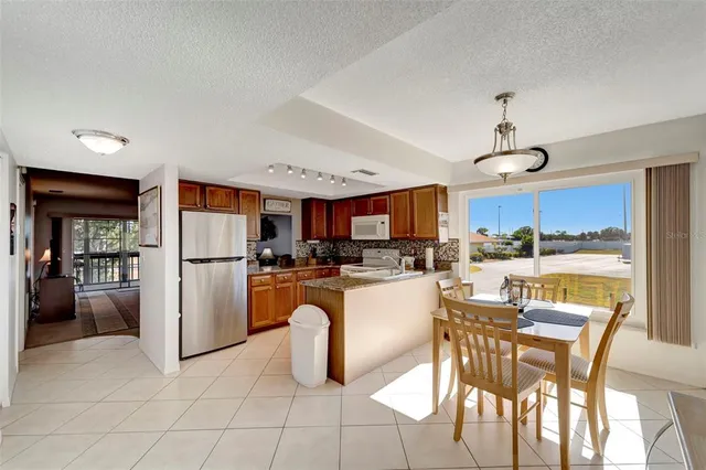 a kitchen with stainless steel appliances granite countertop a refrigerator and a view of living room