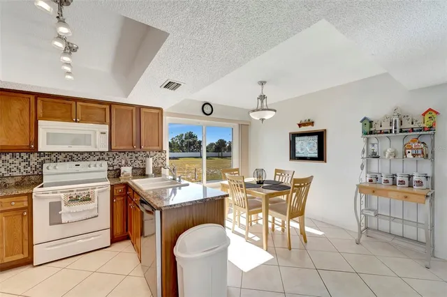 a room with stainless steel appliances kitchen island granite countertop furniture and a view of kitchen