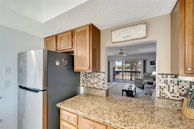 a kitchen with stainless steel appliances granite countertop a refrigerator and a stove