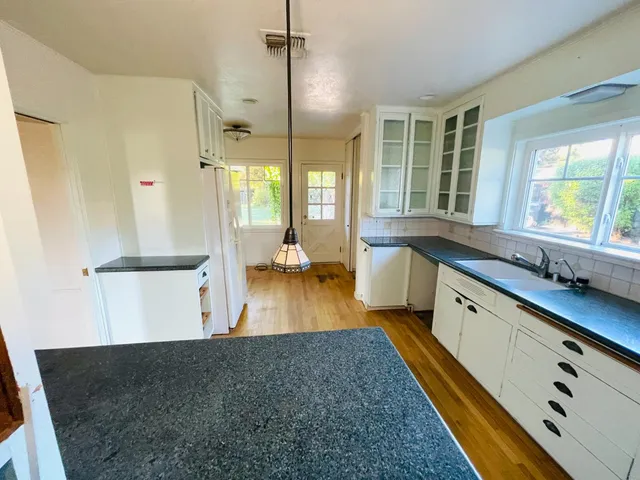 a large white kitchen with a large window