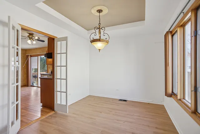 a view of a hallway with wooden floor and cabinet